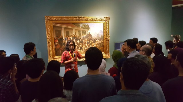 1771-curator-mikke-susanto-explaining-the-significance-of-the-painting-by-raden-saleh-penangkapan-pangeran-diponegoro-1857-during-the-curators-exhibition-tour-image-richard-horstman